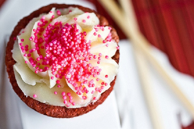 Valentine cake: a cupcake with piped vanilla frosting and pink sprinkles on top.